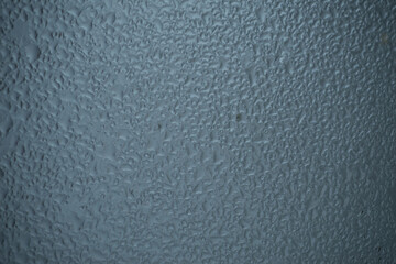 Raindrops on window glass on blur grey background