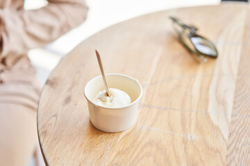 Fototapeta na wymiar Vanilla ice-cream in disposable cups on the table. Italian gelateria. Natural fresh gelato. 