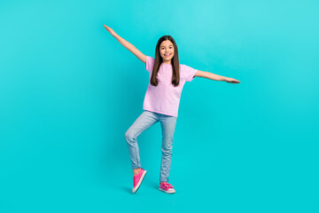 Full body photo of model preteen girl brunette hair wear pink t-shirt jeans flying arms wings careless isolated on blue color background