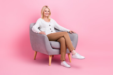 Fototapeta na wymiar Full size photo of satisfied pretty aged person sit chair good mood isolated on pink color background