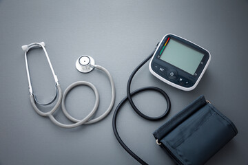 stethoscope with blood pressure measurement machine on dark grey background