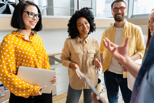 Group of smiling university students studying together, exam preparation, education. Team of business people working in modern office, talking, cooperation, sharing ideas, planning startup on meeting