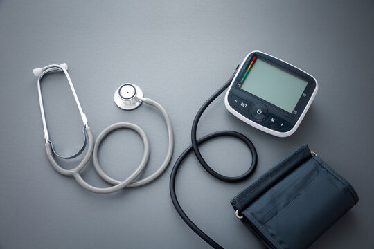 stethoscope with blood pressure measurement machine on dark grey background