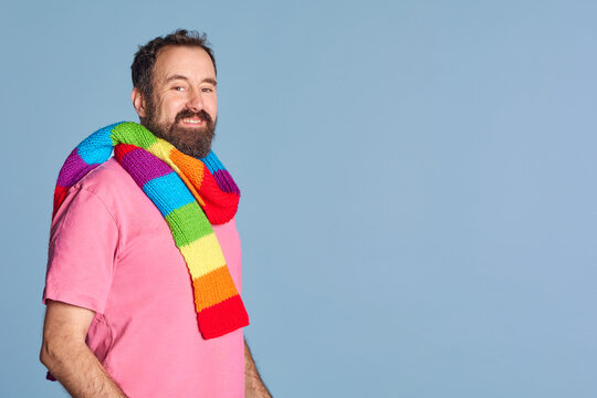 bearded adult lgtb man wearing a scarf with lgtb pride colors. casual clothes, big copy space
