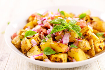 bowl of grilled potatoes with onion and basil