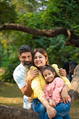 Fototapeta premium Happy indian couple with his little girl at garden.
