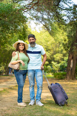 Happy indian couple with suitcases for summer trip. travel concept.