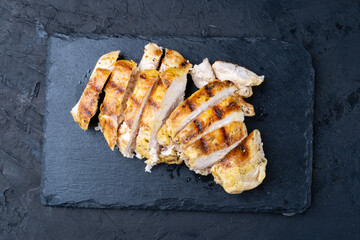 Delicious fried chicken breast, grilled barbecue, dark background, top view.