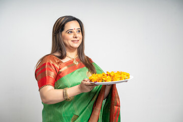 Indian woman wearing traditional sari and holding puja thali in hand. indian festival concept