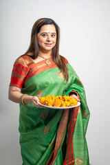 Indian woman wearing traditional sari and holding puja thali in hand. indian festival concept