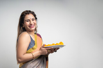 Indian woman wearing traditional sari and holding puja thali in hand. indian festival concept