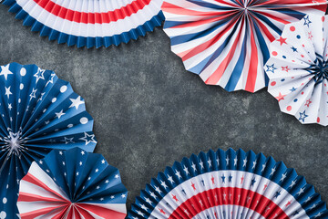 Obraz premium 4th of July background. USA paper fans, Red, blue, white stars, balloons, gold confetti on gray dark concrete background. Happy Labor, Independence or Presidents Day. American flag colors. Top view.