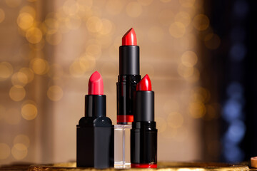 Beautiful red and pink lipsticks against blurred lights
