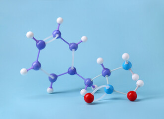Molecule of phenylalanine on light blue background. Chemical model