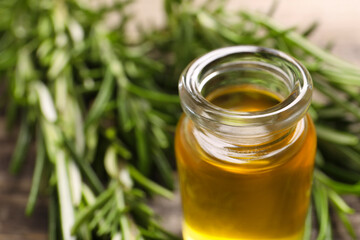 Bottle of rosemary oil on blurred background, closeup. Space for text