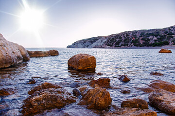 Beautiful sunset at the Aegean sea. Sea with rocks nature landscape background. Travel spa tranquility relax concept 