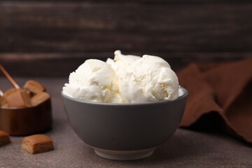 Delicious vanilla ice cream in bowl on textured table