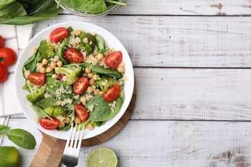 Healthy meal. Tasty salad with quinoa, chickpeas and vegetables on white wooden table, flat lay with space for text