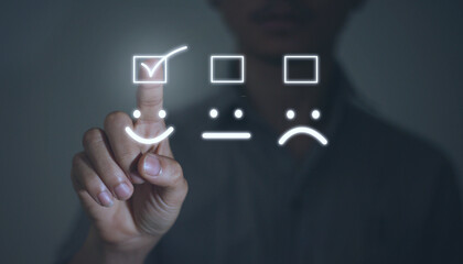 Businessman pointing a smiley face icon to assess satisfaction w