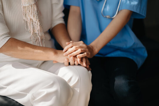 Close Up View Of Old Woman Leaning On Nurse While Siting.