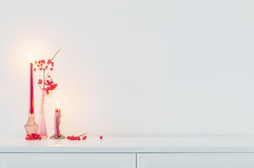 pink christmas decor with burning candles in white interior