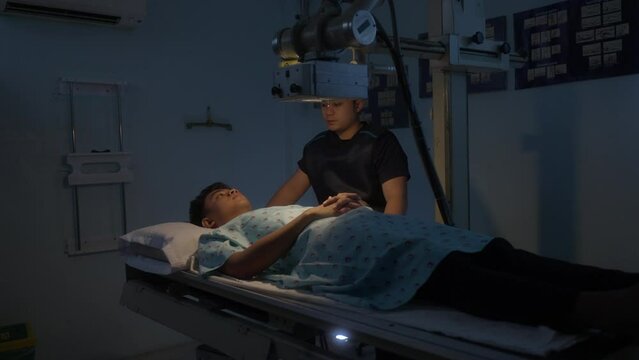 Radiologic Technologist And Male Patient In The X-ray Room. medium shot