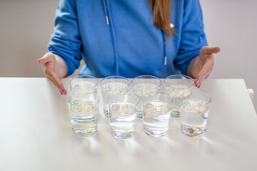 Osiem szklanek wody na stole - obrazy, fototapety, plakaty