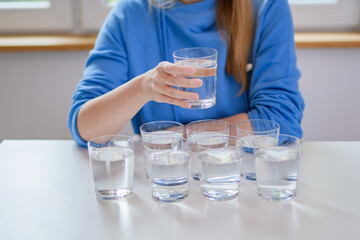 Kobieta pokazująca potrzebna ilość wody do prawidłowego nawodnienia organizmu ludzkiego 