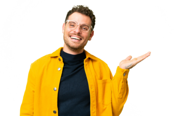 Brazilian man over isolated chroma key background holding copyspace imaginary on the palm to insert an ad