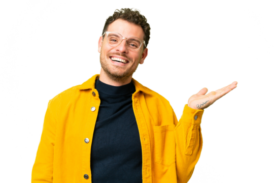 Brazilian man over isolated chroma key background holding copyspace imaginary on the palm to insert an ad