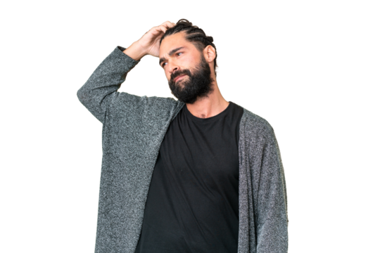 Young man with beard over isolated chroma key background having doubts while scratching head
