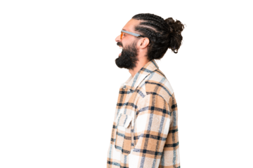 Young man with beard over isolated chroma key background laughing in lateral position