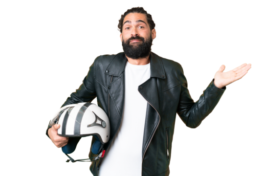 Young man with beard with a motorcycle helmet over isolated chroma key background having doubts while raising hands