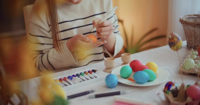 Mother and daughter are painting Easter eggs for Easter Holidays