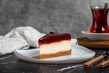 Cheesecake with raspberry flavor on a dark background. a piece of cheesecake on a white plate