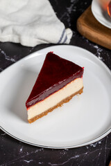 Cheesecake with raspberry flavor on a dark background. a piece of cheesecake on a white plate