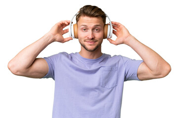 Young blonde caucasian man over isolated background listening music