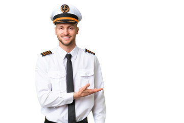 Airplane pilot man over isolated background presenting an idea while looking smiling towards © luismolinero
