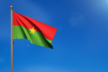 Burkina Faso. Flag blown by the wind with blue sky in the background