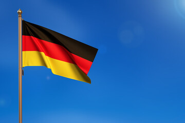 Germany. Flag blown by the wind with blue sky in the background