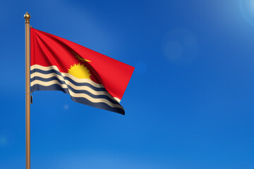 Kiribati. Flag blown by the wind with blue sky in the background