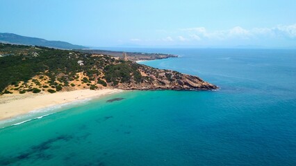 Fototapeta premium Faro de Camarinal, aerial view of the lighthouse on a cliff at the the wonderful sandy beach with the blue turquoise Atlantic Ocean, Playa Los Alemanes, Andalusia, Spain