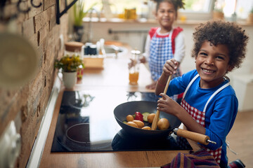 Kitchen Playtime: Afro-American Siblings Master the Art of Culinary Fun - 613854241