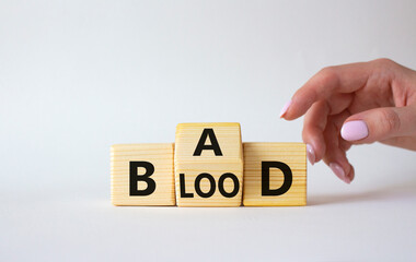 Breed Bad Blood symbol. Businessman hand turns wooden cubes with words Breed Bad Blood. Beautiful white background. Breed Bad Blood and business concept. Copy space