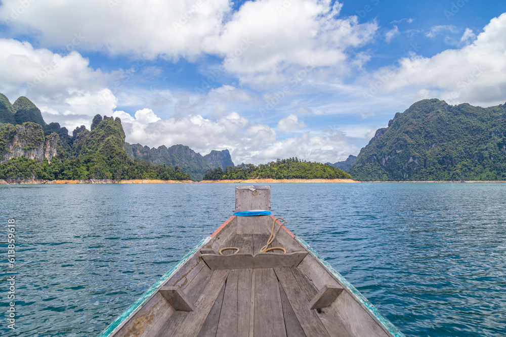 Poster The Wooden Thai traditional long-tail boat on a lake with mountains at Ratchaprapha Dam or Khao Sok National Park, Surat Thani Province, Thailand