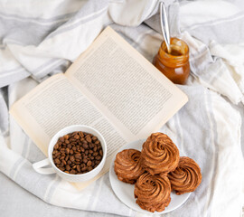 homemade marshmallow zephyr with coffee and caramel.natural ingredients.open book coffee cup.woman hand taking one piece.smiling face from coffee beans.dessert in box, or torn paper, diagonal lines