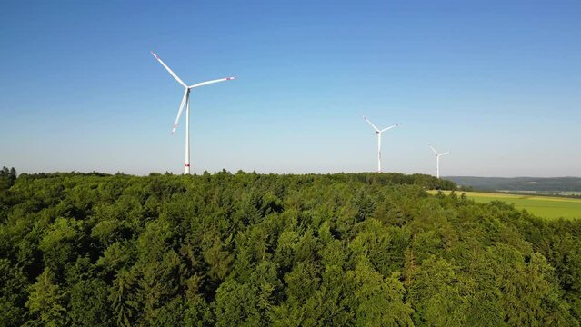 Windkraftwerk im Wald mit blauen Himmel