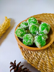 Obraz premium Kelepon or Klepon is a traditional Indonesian food made from glutinous rice flour filled with brown sugar and sprinkled with grated coconut.