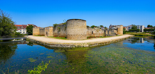 Water-filled moat below the round corner tower of the medieval castle of Brie Comte Robert in the...
