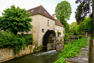 Water mill in the Canal of the Loing in the city center of Nemours, a small town in the south of the Seine et Marne department in Paris region, France - obrazy, fototapety, plakaty